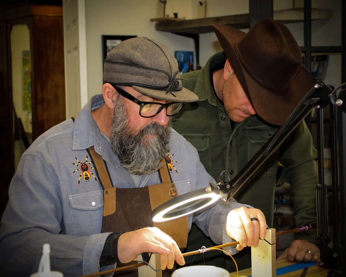An instructor at PJ's Fine Bamboo Rods in Pagosa Springs shows an on looking student how to wrap their homemade fly-fishing rods.