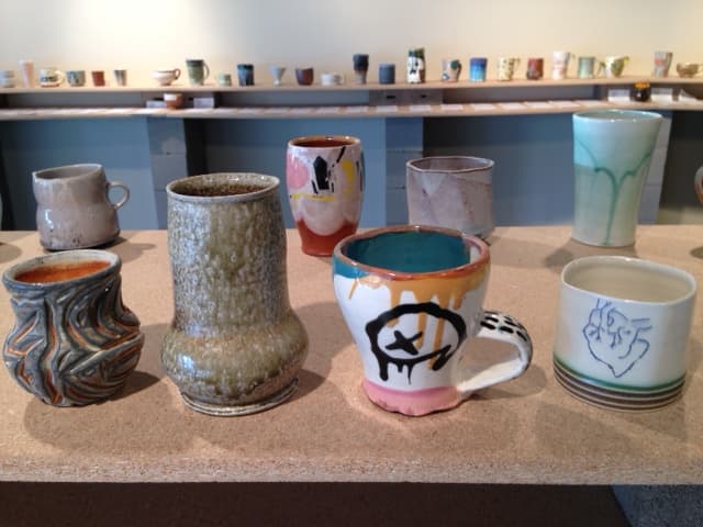 Ceramic items sit on a shelf in a pottery store