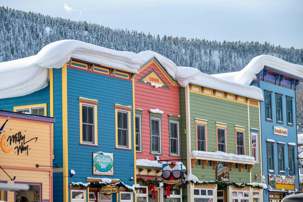 Downtown Crested Butte's colorful historical storefronts covered in winter snow