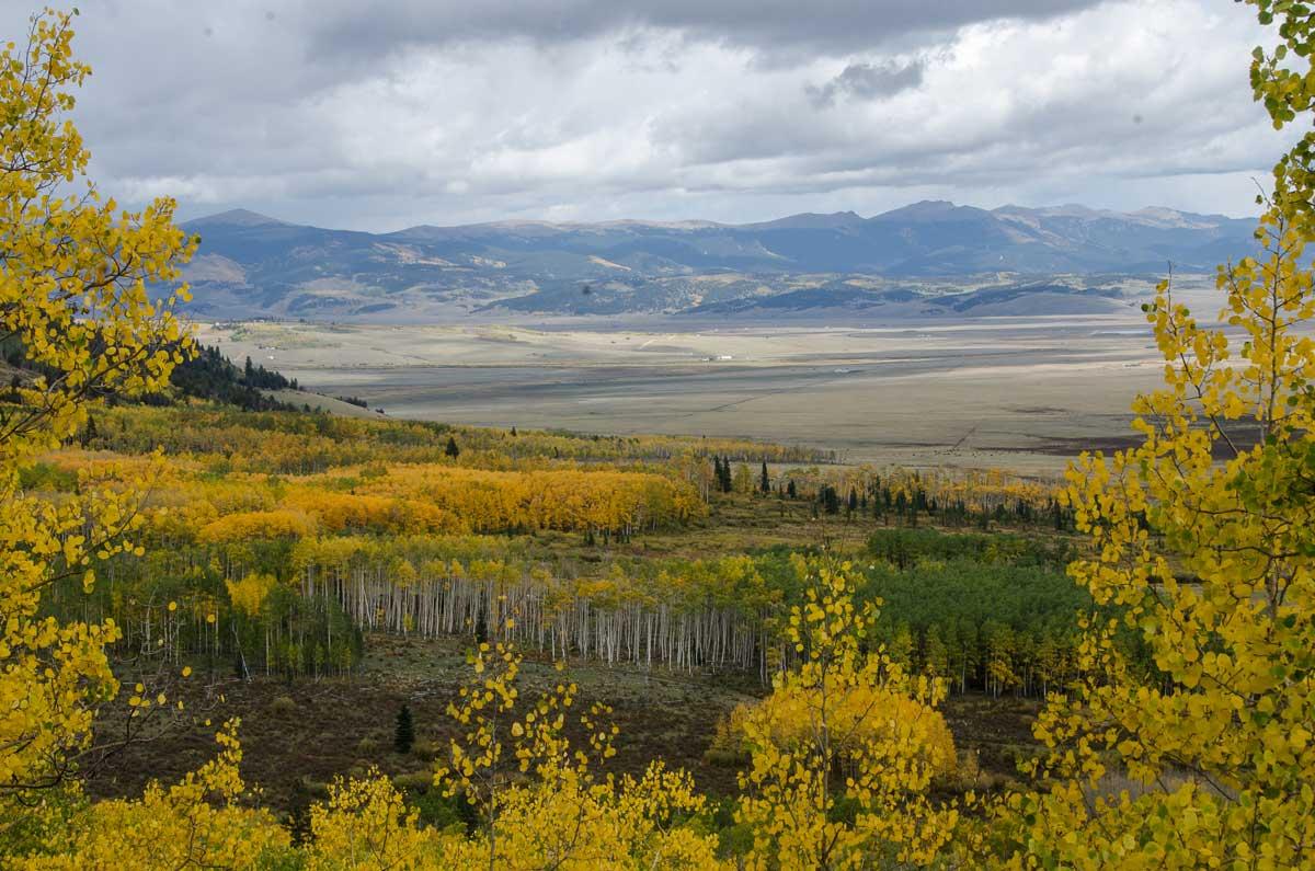 A view from Boreas Pass in Colorado shows a valley with golden fall colors and open fields. 