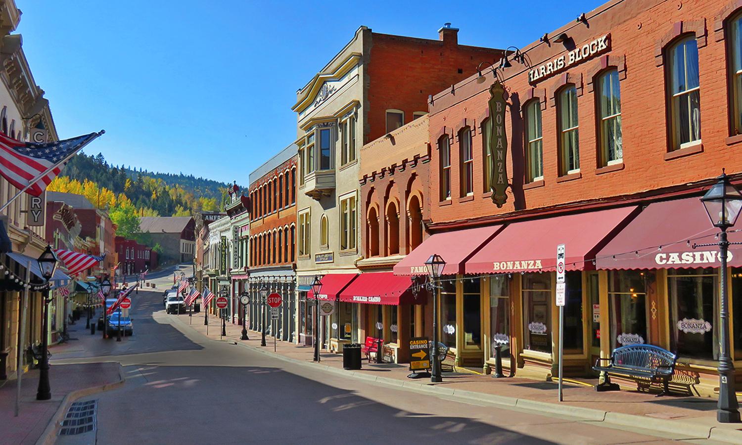 Downtown Central City with red-brick buildings with red awnings on a blue-sky day.