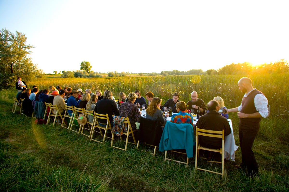 People having dinner at a table in a field in Boulder, Colorado