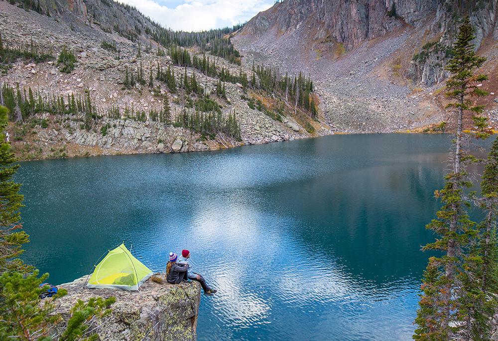 Campers sit on a cliff edge overhanging a mountain lake near Steamboat Springs