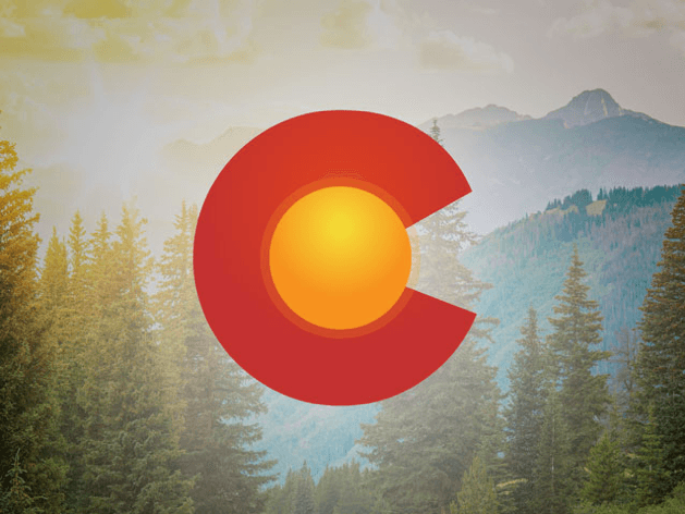 Red Colorado C with gold circle in the middle on a background image of hazy mountains with pine trees in the foreground.