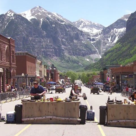 Top Chef contestants cooking in the middle of the road in downtown Telluride with the mountains in the background