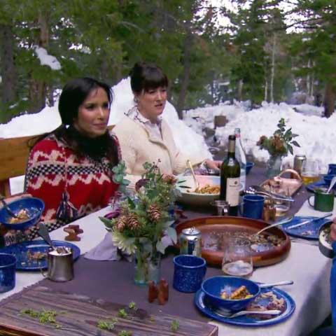 Padma Lakshmi dining outside at a table with snow in the background