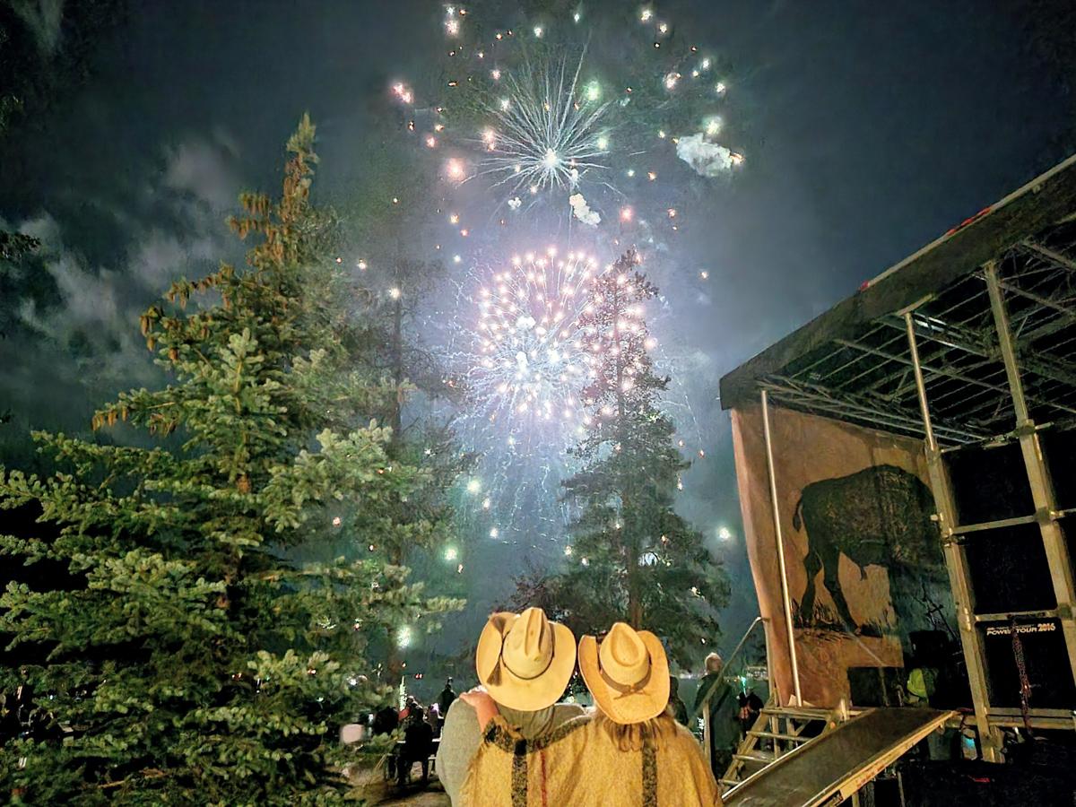 Fireworks during Buffalo Days in Grand Lakes, Colorado with two people wearing cowboy hats looking up at the sky. 