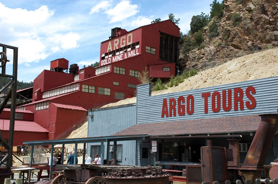 Exterior shot of Argo Gold Mine & Mill in Idaho Springs, Colorado, a bright red building made of several layers built into the mountainside