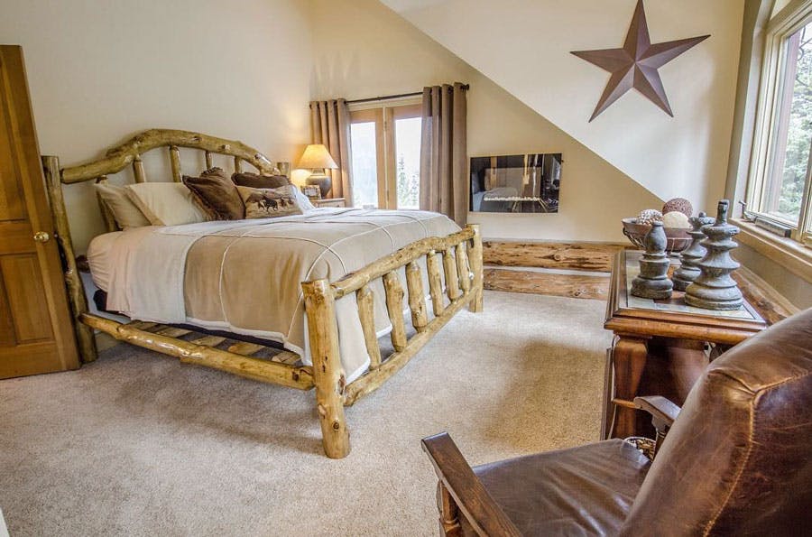 A bed and wood-burning stove inside a cozy bedroom at a hotel in Idaho Springs