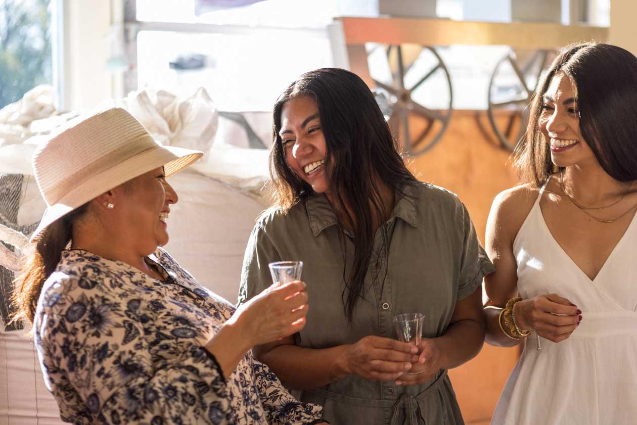 Three women laugh on a brewery tour