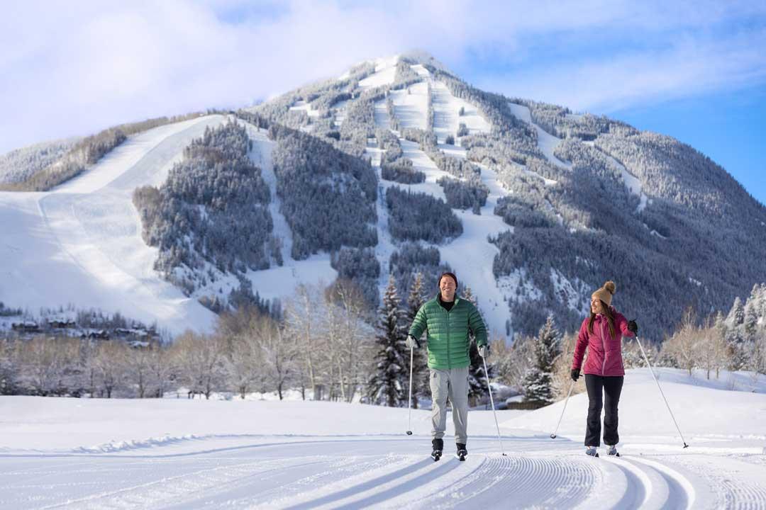 Two people glide on a groomed cross-country trail