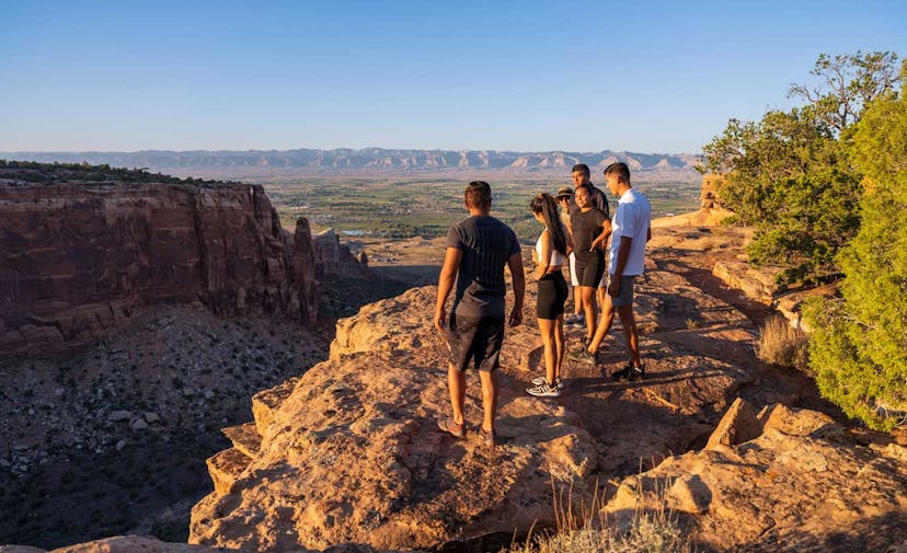 A group of hikers peer into a red-rock canyon