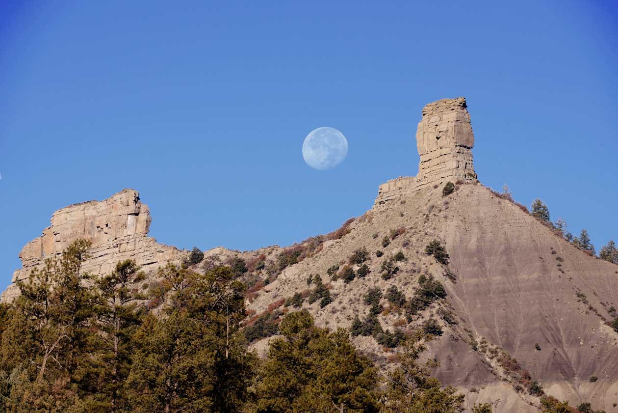 The moon lines up between two rock formations