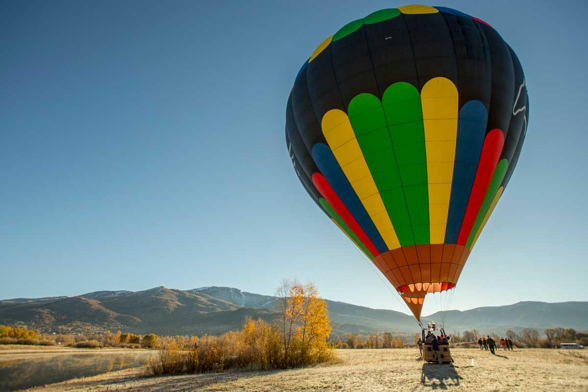 A hot air balloon rests on the ground waiting to take flight