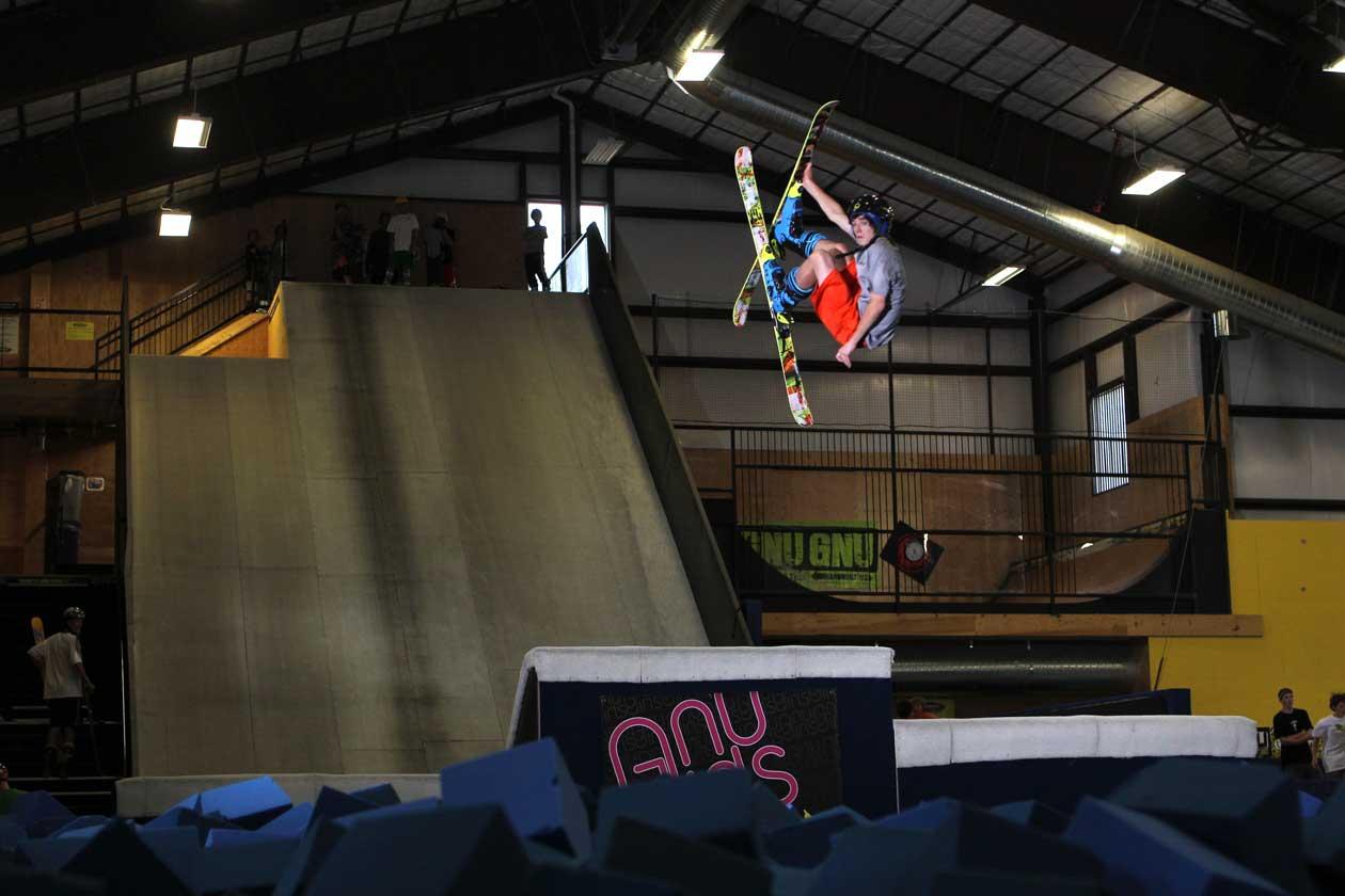 A skier practices a trick over a foam pit