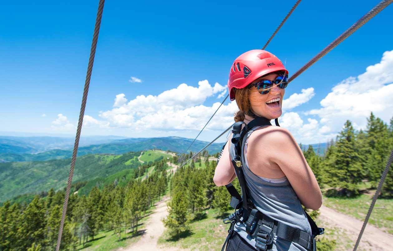 A woman looks at the camera just as she's about to set off on a zipline