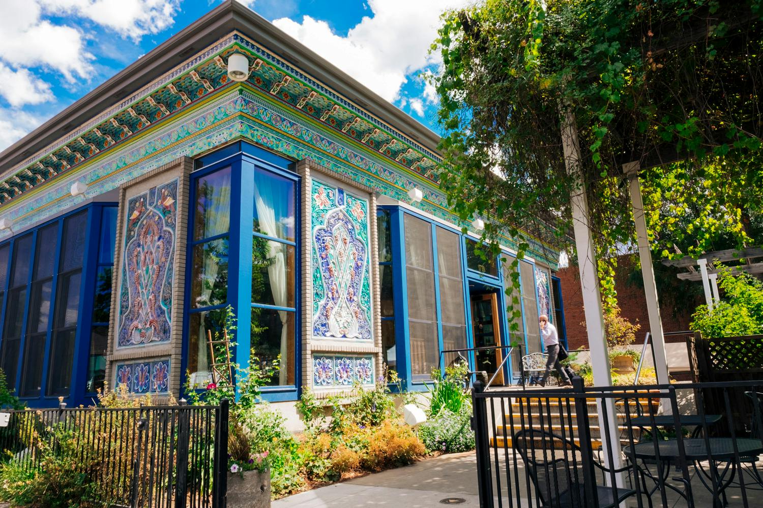 A building with tile mosaics on its walls in a town setting