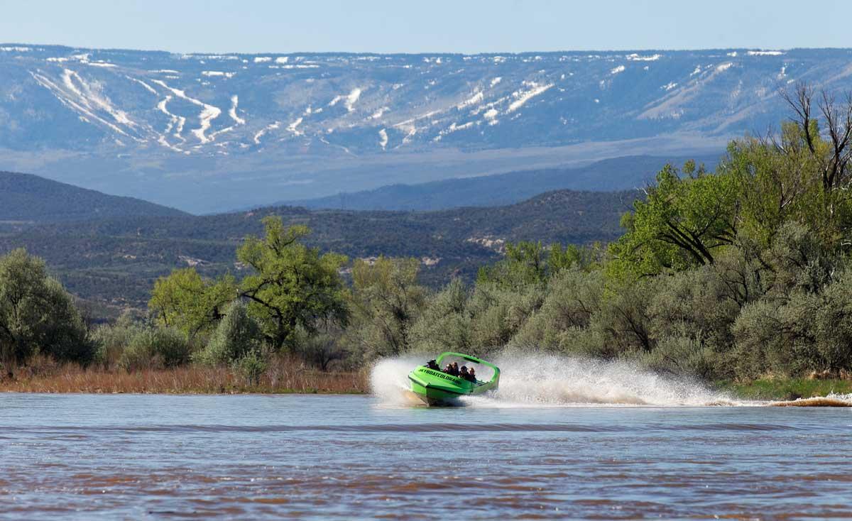 Jet boat cutting through the water on a sunny day near Grand Junction