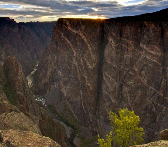 A winding river lies at the bottom of the vertical rock walls of Black Canyon of the Gunnison National Park near Montrose.