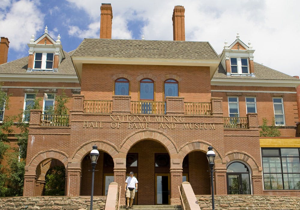 The National Mining Hall of Fame and Museum is a red-brick building with a set of arches at the entrance in Leadville.