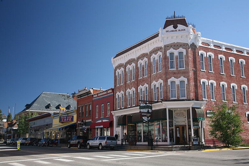 On the corner of a street in Leadville, Colorado, stand the grand, red-brick Delaware Hotel with charming white arches over each window.