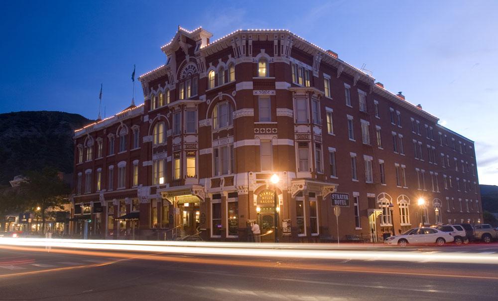 Lights line the roof of the brick and marble Historic Strater Hotel in Durango, Colorado. The light glow bright as the evening sky darkens.