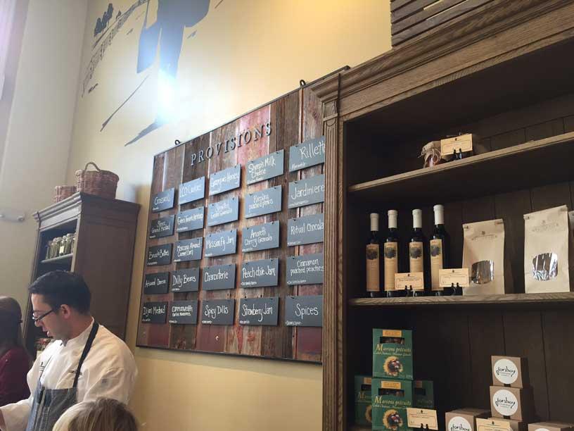 A shop at Union Station in Denver, Colorado, has dark-wood shelving featuring food products in bottle and sealed bags.