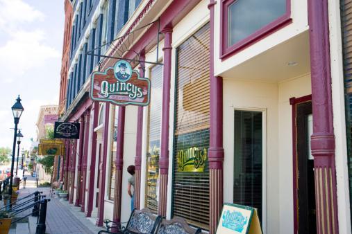 Boutique storefronts in Leadville, Colorado, feature a vibrantly colored design accents. The stores line a cobbled pedestrian walkway.