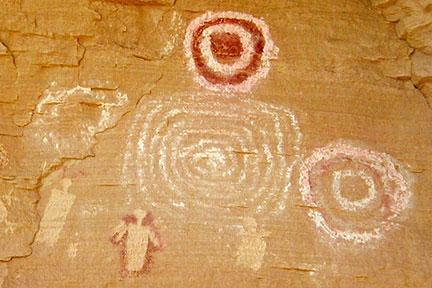 White and red pictographs of the Freemont Indian culture appear to be drawings of humans on the cliff wall