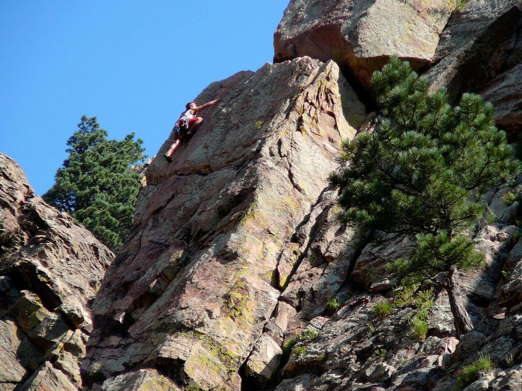 A person rock climbing on a sunny day in Eldorado Canyon State Park in Eldorado Springs