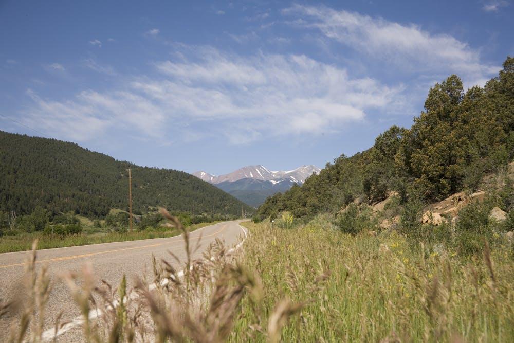 A long road winds through the valley with mountains on both sides