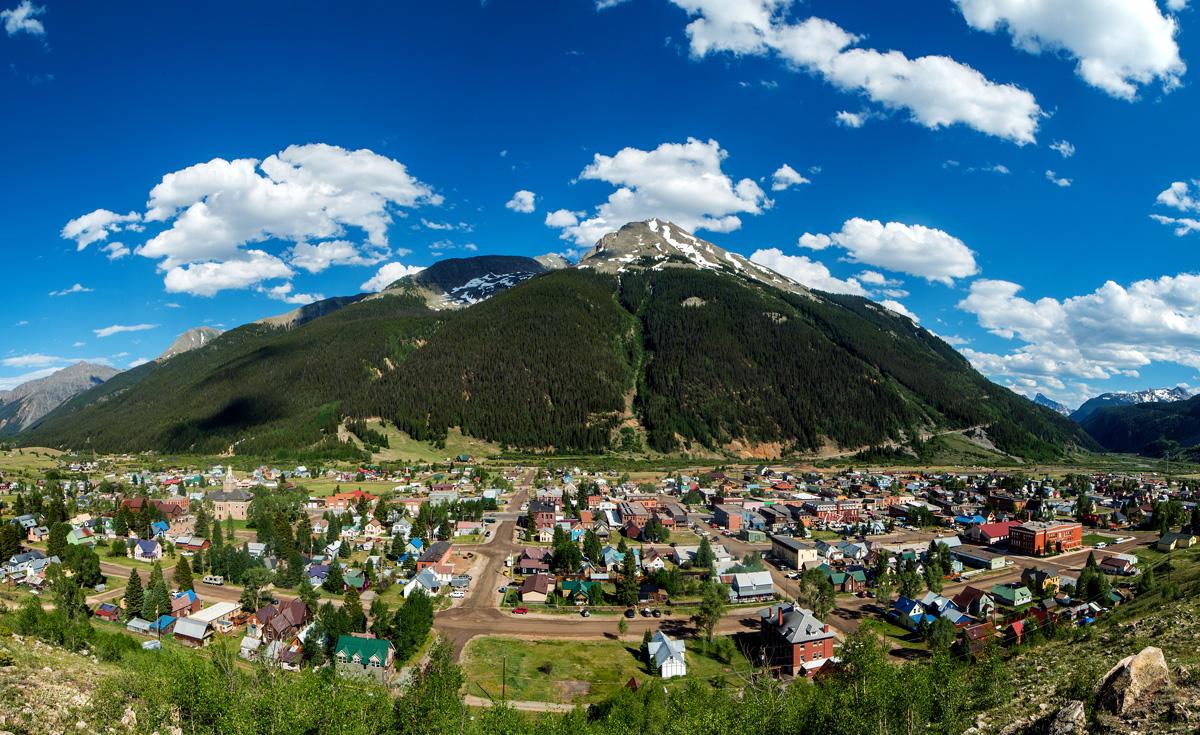 An aerial view of downtown Silverton with an evergreen-covered mountain in the background.