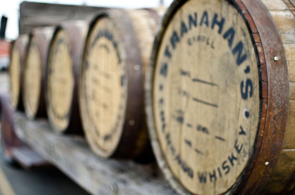 Five wood whiskey barrels lay on their sides in a row on a sturdy shelf at Stranahan's Colorado Whiskey in Denver.