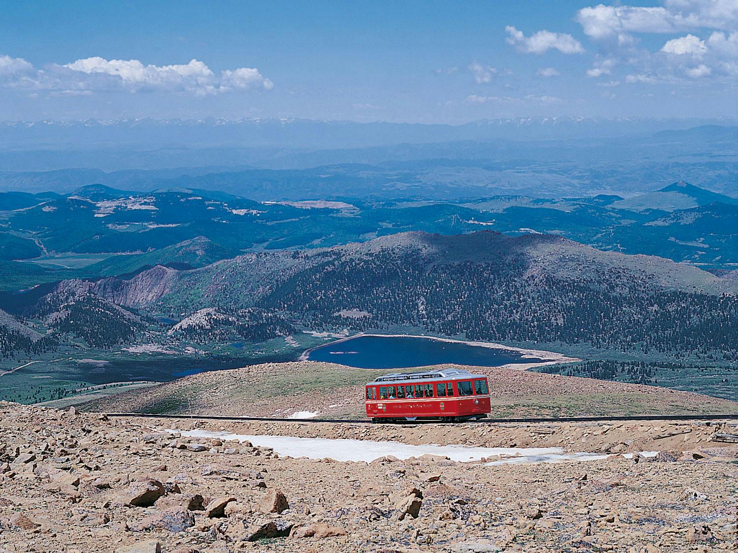 A single train car rides along a mountaintop track