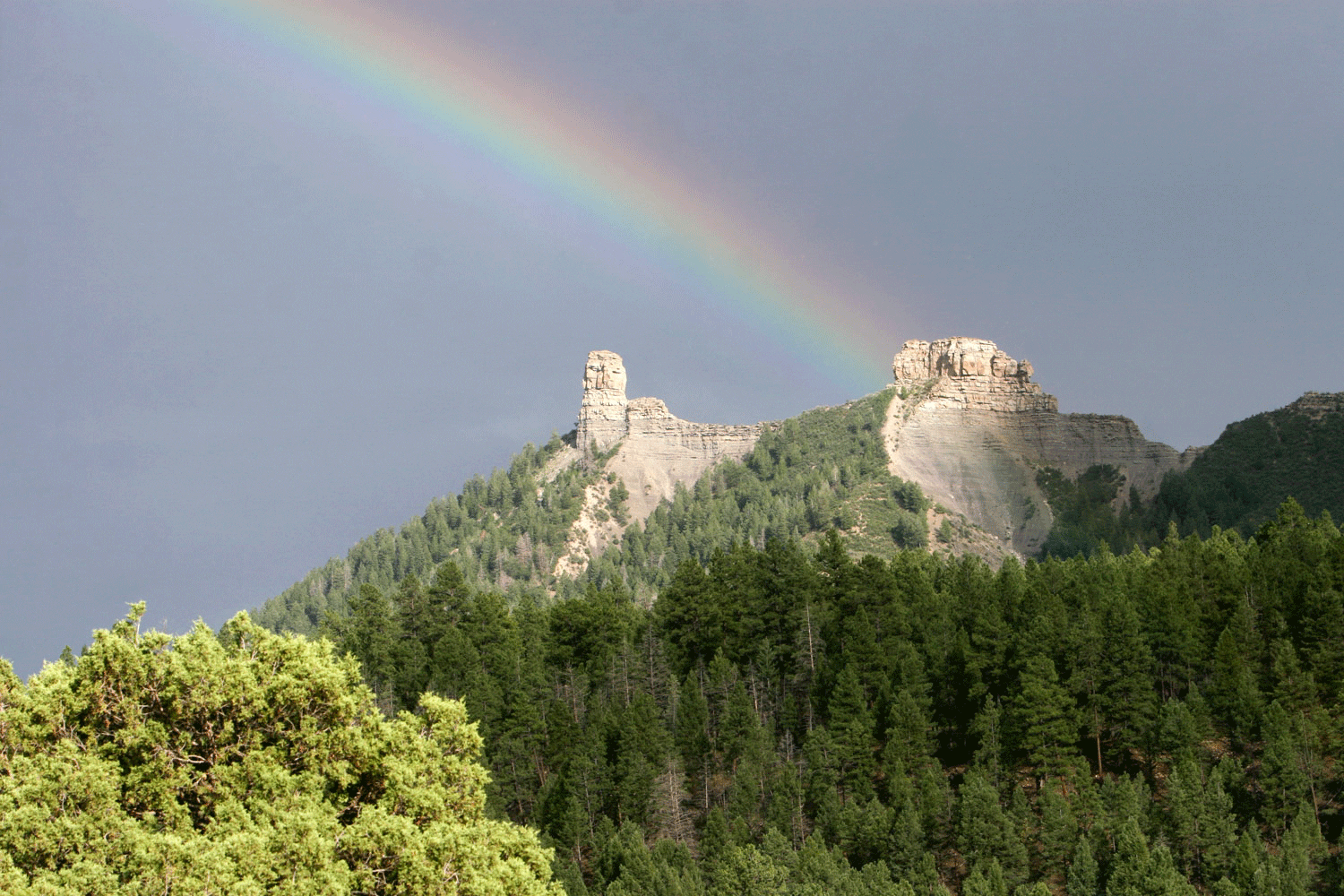 A rainbow appears and touches a white rock formation at Chimney Rock National Monument near Pagosa Springs.