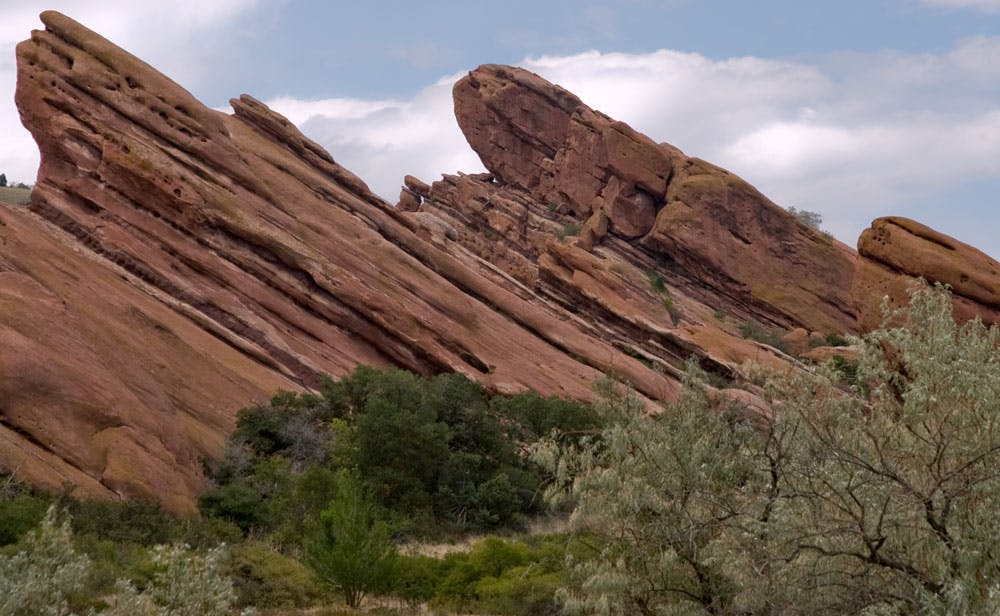 Slanted red rocks seem to burst out of the ground, reaching toward the sky