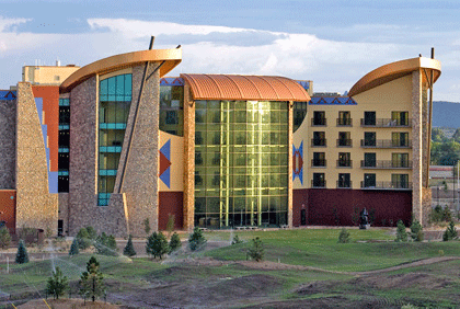 A hotel with polished, sloped roofs and design elements and patterns inspired by Indigenous art stands tall in the southwest Colorado town of Ignacio. Newly planted pine trees are spread about the grounds.