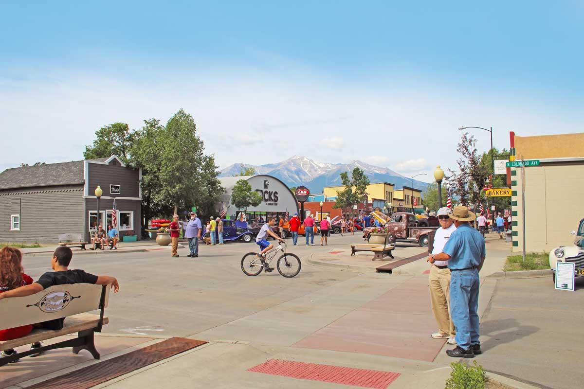 Downtown Buena Vista in the summer with lots of people walking around. In the center a man is on a bike.