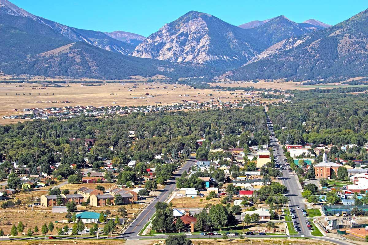 An aerial shot of Buena Vista in the summer with the tall Collegiate Peaks in the background under a bright-blue sky