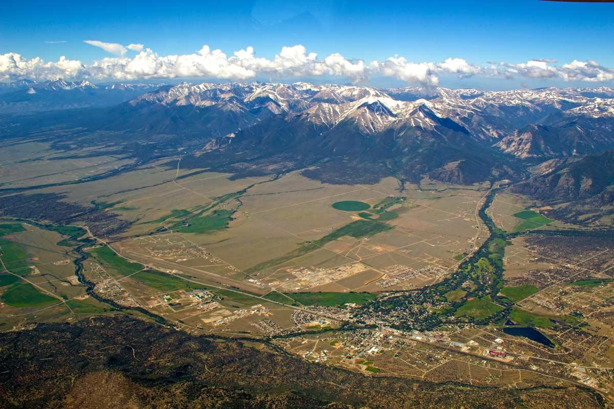 Bird's-eye view of Buena Vista with a bright-blue sky, cotton-ball clouds and snow-capped mountains in the summer.