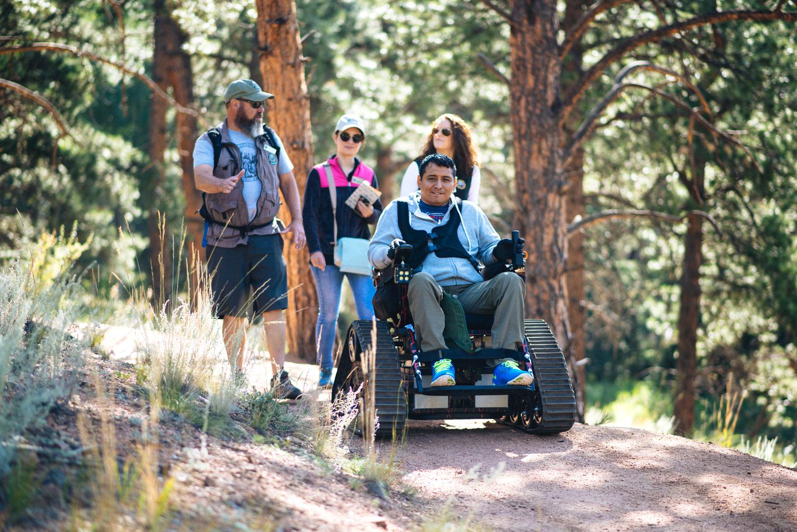 An outdoor adventurer hits the trails in an adaptive wheelchair with thick, rubber treads at Staunton State Park in Colorado.