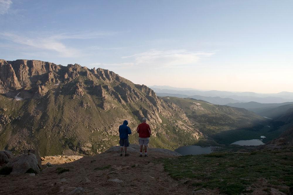 Hikers stop to see the Rocky Mountains disappearing into the horizon