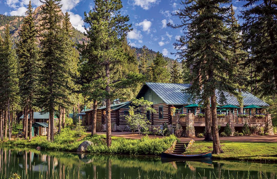 The Broadmoor Fly-Fishing Camp set alongside a creek among evergreens