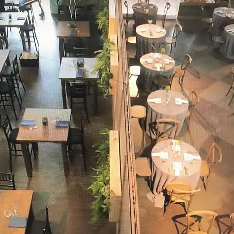 Rows of tables in a restaurant set for a meal