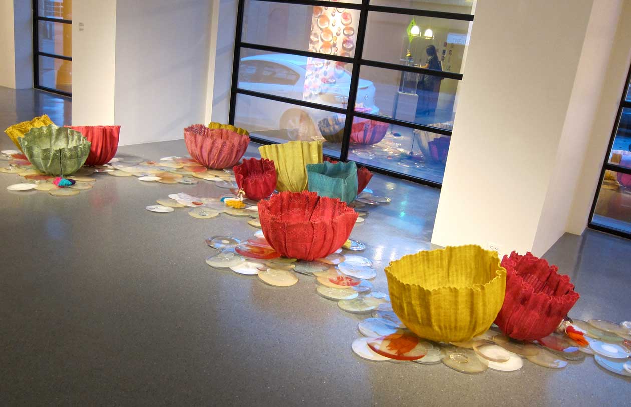 A display of colorful ceramic flowers in a gallery
