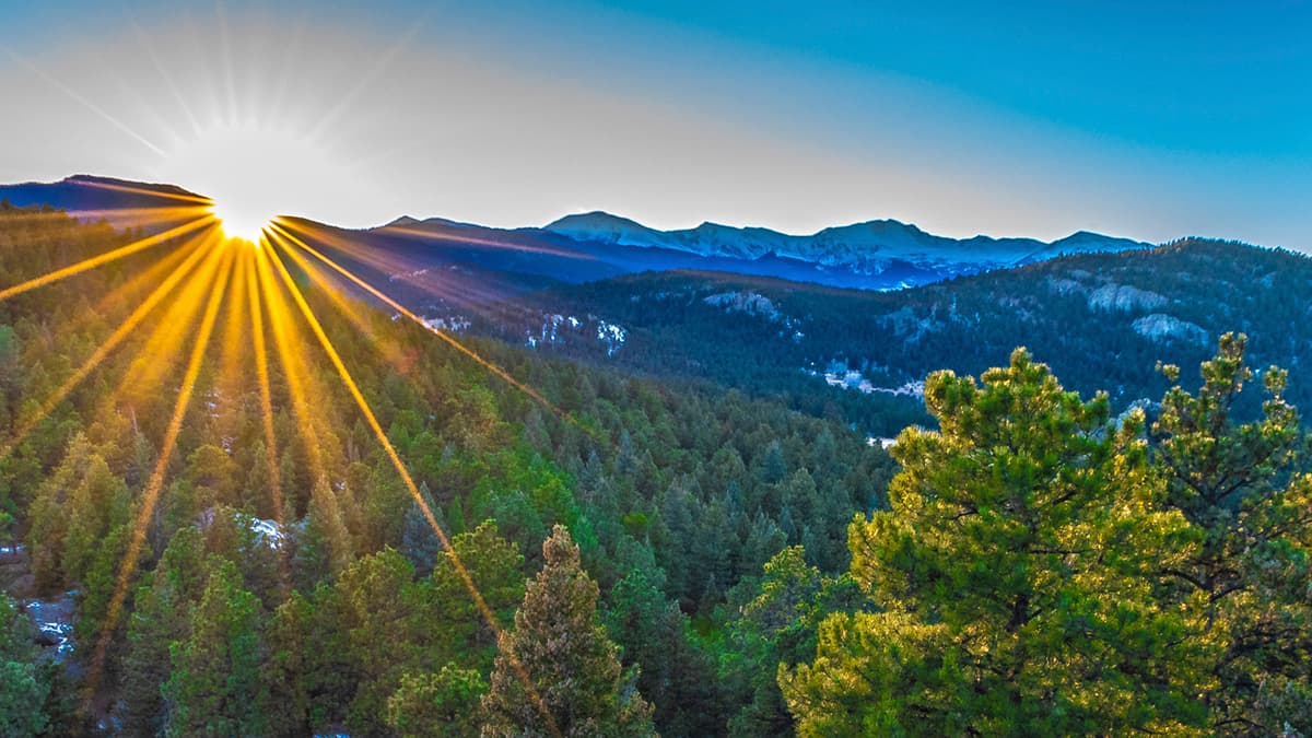 A sunrise rising over mountains in Evergreen.