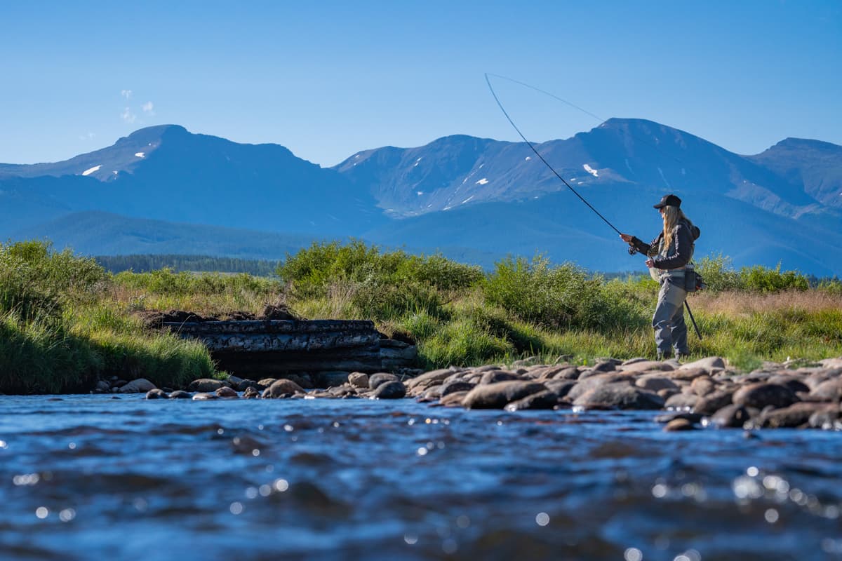 Someone sends a fly-fishing line into blue waters in Winter Park.