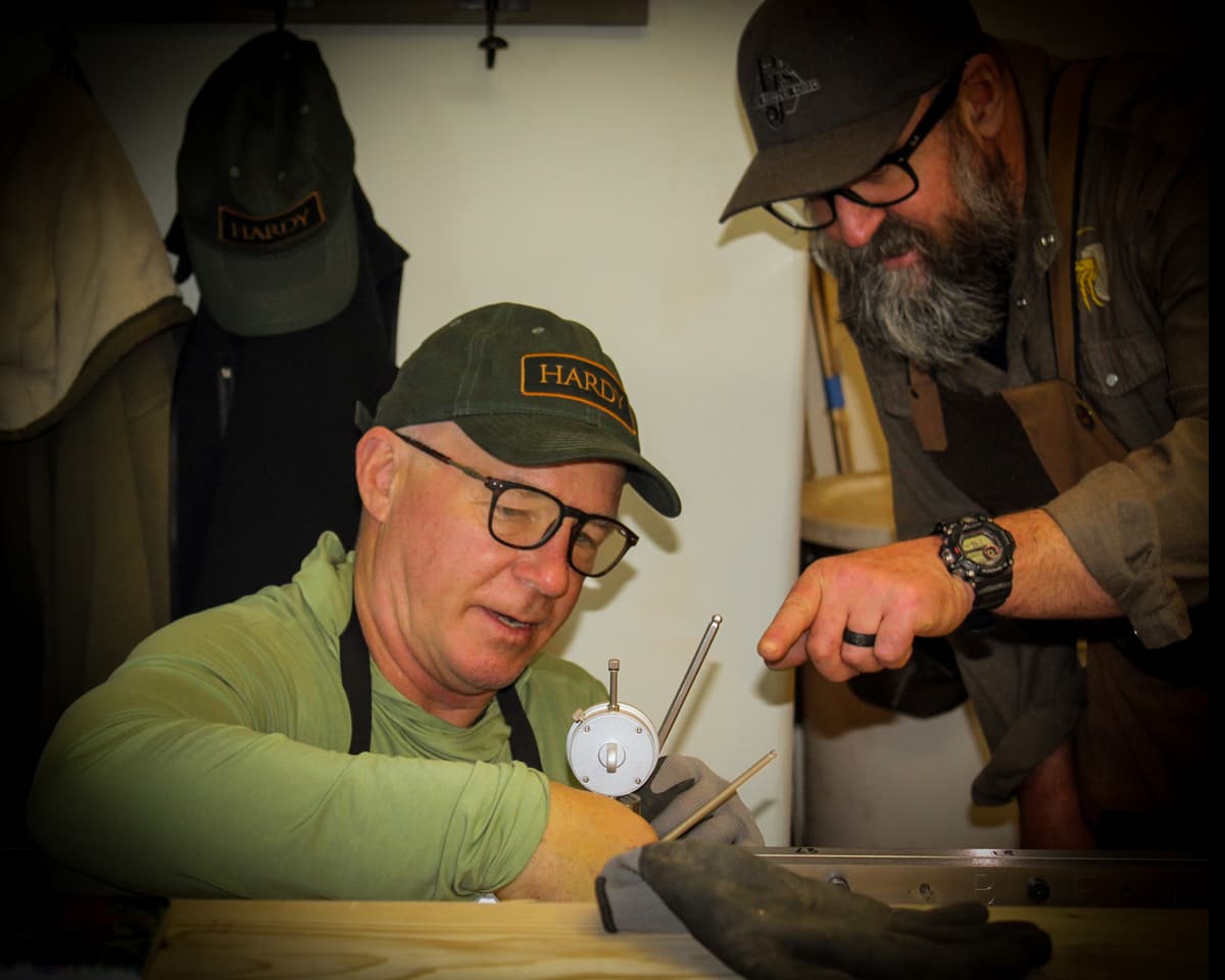 One instructor and one student talk together and look at a fly rod in the workshop at PJ's Fine Bamboo Rods in Pagosa Springs.