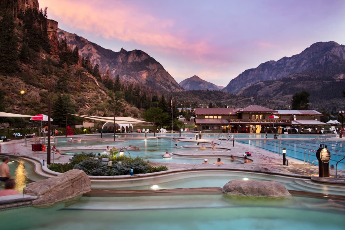 People soaking in pools and admiring the mountain views at Ouray Hot Springs Pool in Colorado