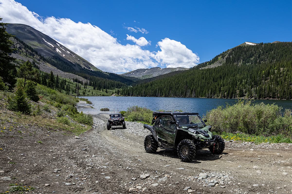 Two ATVs drive on a trail near the Taylor river. The riders are enjoying an excursion with Harmels on the Taylor.